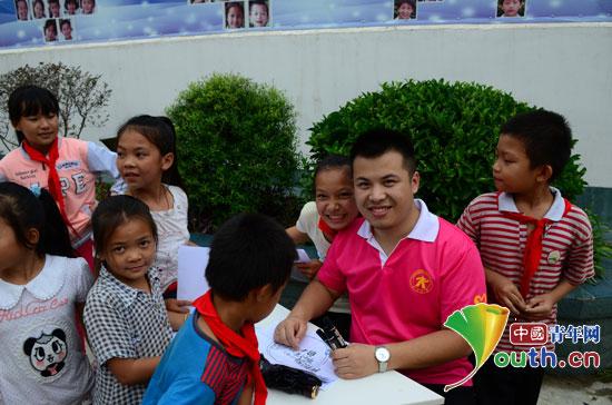 郑州大学研究生支教团广西（融水）服务队在贝林小学开展心愿认领活动。图为志愿者帮孩子填写心愿卡。